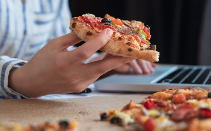 hand holding pizza