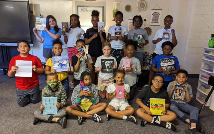 fourth grade students holding books