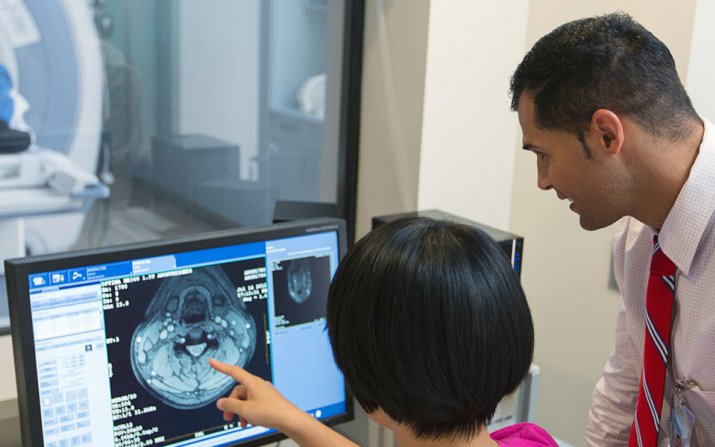 two clinicians reviewing a brain scan