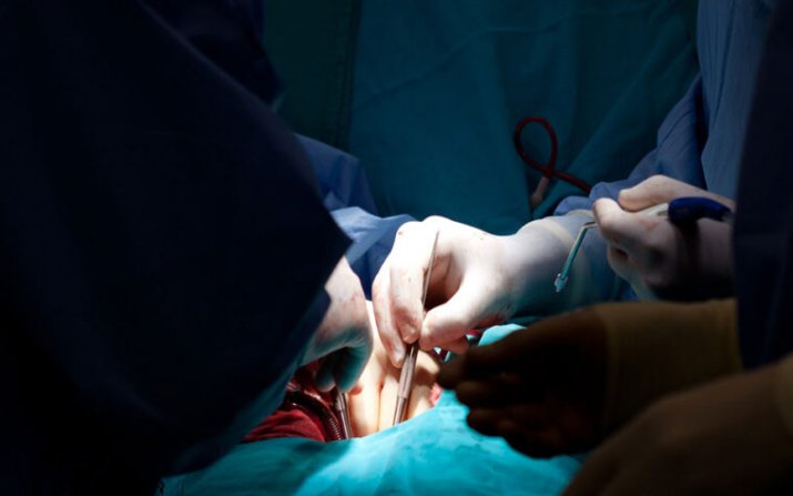 surgeon's hands performing heart surgery