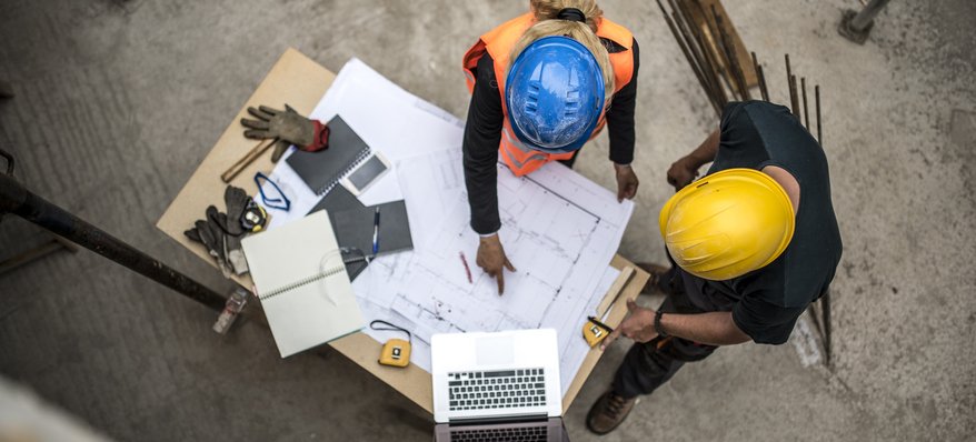 engineers in hardhats reviewing plans