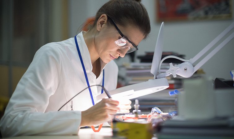 Researcher working on electronics in a lab 