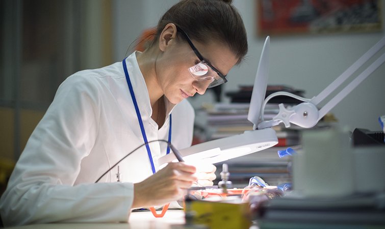 Researcher working on electronics in a lab