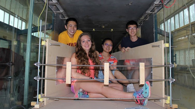 Andrew Wang, Amber Phillps, HongXiang "Nicole" Yue from Lanzhou University and Dan Gil pose inside the structure they built to test electrostatic charging inside the wind tunnel.