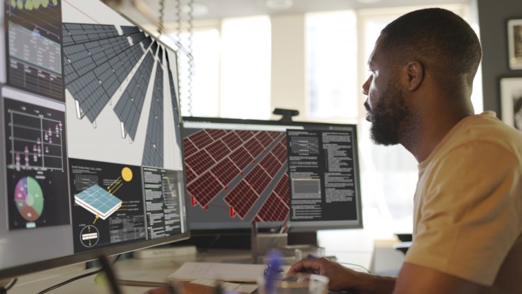  Close-up image of an African American man working with CAD software on the design of a solar panel array