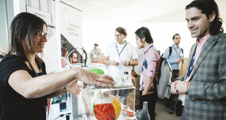 people at the International Symposium on Academic Makerspaces looking at 3-D printed parts