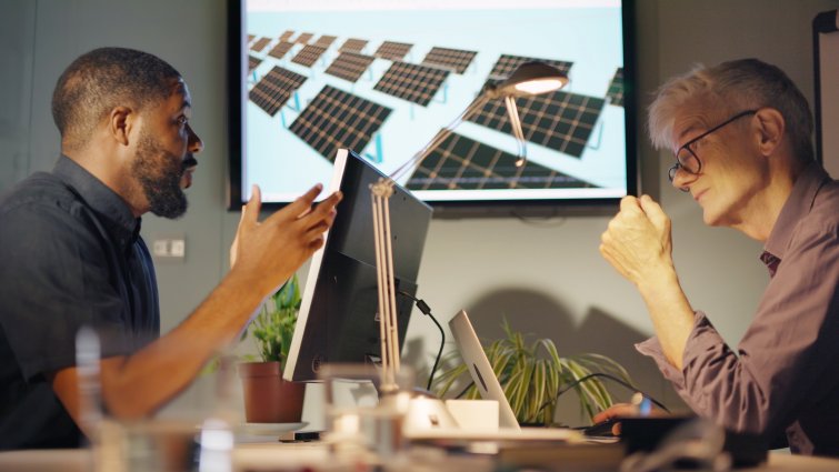 Stock image of two men, one black and the other white & mature meeting to discuss solar pale installation design