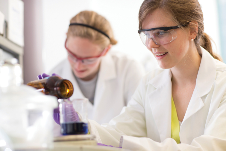 Photo of students conducting experiment in a lab