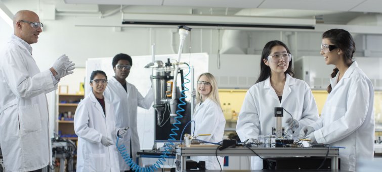 Professor instructing undergraduate students in a lab